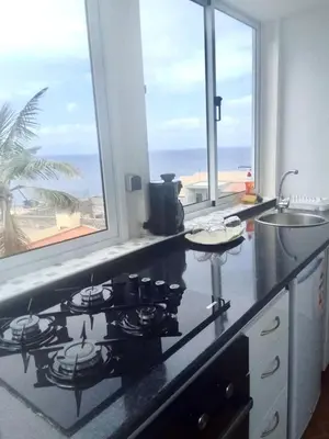a kitchen with a stove and a view of the ocean at Oásis de retour in Ponta do Sol