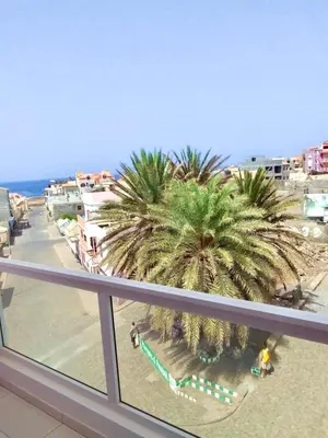 a view of a beach with palm trees from a balcony at Oásis de retour in Ponta do Sol