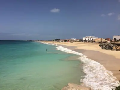 a beach with a person standing in the water at Joli et fonctionnel proche centre et plage in Vila do Maio