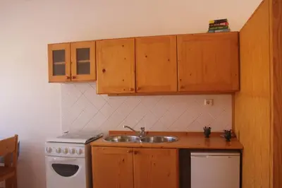 a kitchen with a sink and a stove and cabinets at Joli et fonctionnel proche centre et plage in Vila do Maio