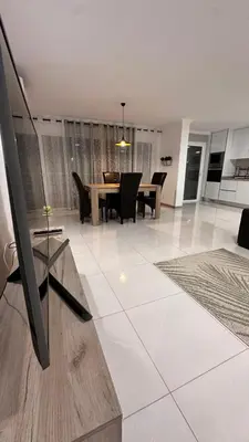 a dining room and living room with a table and chairs at Duarte Apartments - Império in Mindelo