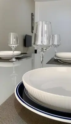 two wine glasses and a plate on a table at KANDAKE APARTMENT II Sal Rei Wi-fi in Sal Rei