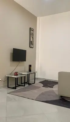 a living room with a table and a tv on a wall at KANDAKE APARTMENT II Sal Rei Wi-fi in Sal Rei