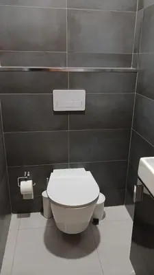 a bathroom with a white toilet and a sink at Mendes Guesthouse in Tarrafal