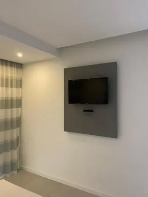 a flat screen tv on a wall in a room at Mendes Guesthouse in Tarrafal