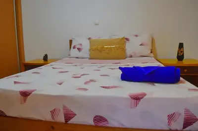a bed with pink and white sheets and pillows at Suíte Salinas - Vila Cabral 2 in Sal Rei