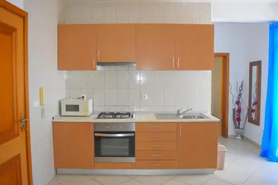 a small kitchen with a microwave and a sink at Suíte Salinas - Vila Cabral 2 in Sal Rei