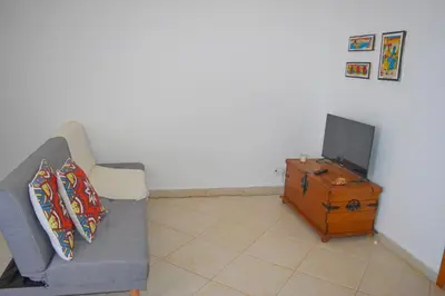 a living room with a couch and a tv at Suíte Salinas - Vila Cabral 2 in Sal Rei