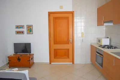 a kitchen with a door and a television in it at Suíte Salinas - Vila Cabral 2 in Sal Rei