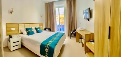 a hotel room with a bed and a television at Lily holiday hotel in Mindelo