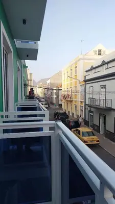 a balcony of a building with a yellow taxi at Lily holiday hotel in Mindelo