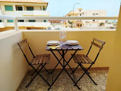 a table and two chairs sitting on a balcony at Onda do Mar in Santa Maria