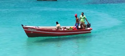 three people standing on a boat in the water at Onda do Mar in Santa Maria