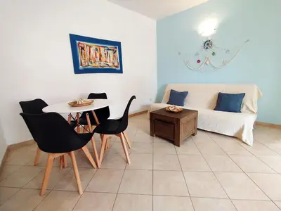 a living room with a table and chairs and a couch at Onda do Mar in Santa Maria