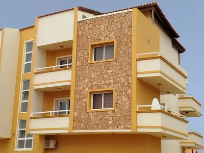 a facade of a building with yellow at Onda do Mar in Santa Maria