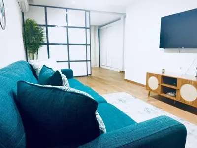 a living room with a blue couch and a flat screen tv at My Home CV in Praia