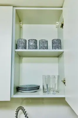 a cupboard with plates and glasses and dishes on it at My Home CV in Praia