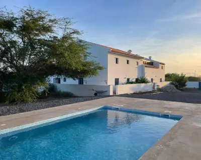 a villa with a swimming pool in front of a house at Magnifique villa avec piscine privée à 300m de la plage in Vila do Maio