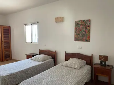 a room with two beds and a picture on the wall at Magnifique villa avec piscine privée à 300m de la plage in Vila do Maio