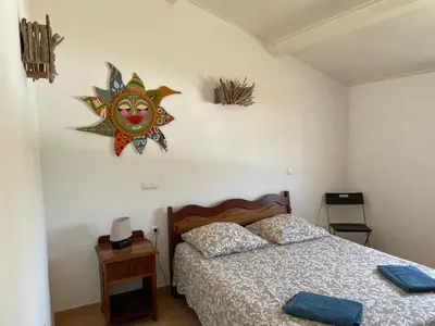a bedroom with a bed and a painting on the wall at Magnifique villa avec piscine privée à 300m de la plage in Vila do Maio
