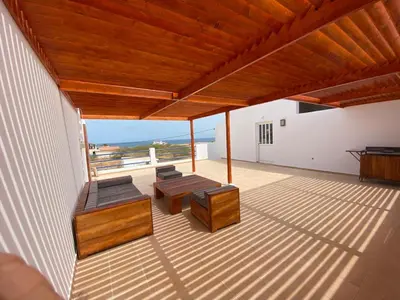 a patio with benches and tables on a building at Magnifique villa avec piscine privée à 300m de la plage in Vila do Maio