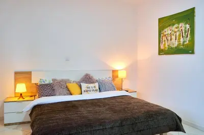 a bedroom with a large bed and two lamps at Super Cozy One-Bedroom Apartment in Santa Maria