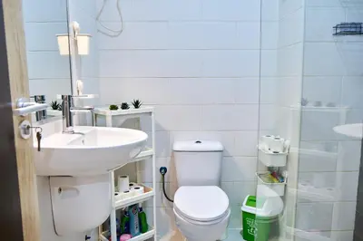 a bathroom with a white toilet and a sink at Super Cozy One-Bedroom Apartment in Santa Maria