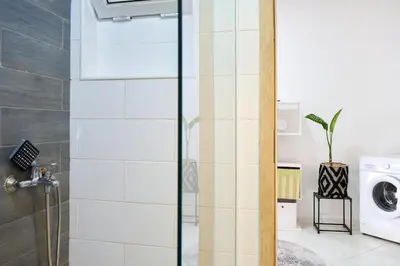 a bathroom with a shower and a washing machine at Super Cozy One-Bedroom Apartment in Santa Maria