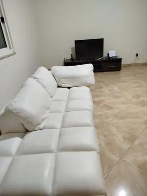 a white couch in a living room with a tv at Apartamento espaçoso de 2 quartos amplos e mobilados in Praia