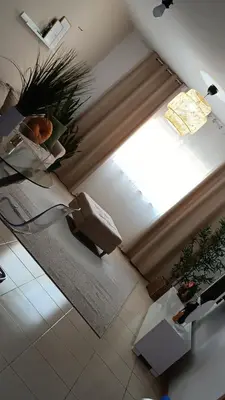 a room with a window and a table with a plant at Apartamento em Praia - Palmarejo in Praia