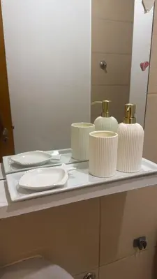 a bathroom counter with three white cups and a mirror at Apartamento em Praia - Palmarejo in Praia