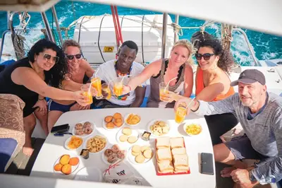 a group of people sitting around a table on a boat at Privat Apartment with Pool View! in Santa Maria