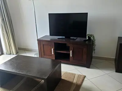 a living room with a flat screen tv on a wooden entertainment center at Privat Apartment with Pool View! in Santa Maria