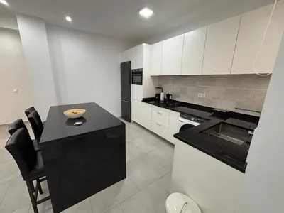 a kitchen with a black counter and white cabinets at Urban Mindelo in Mindelo