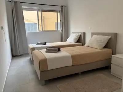 two beds in a room with a window at Urban Mindelo in Mindelo