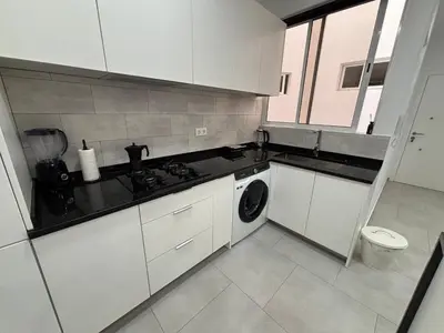 a kitchen with white cabinets and a washing machine at Urban Mindelo in Mindelo