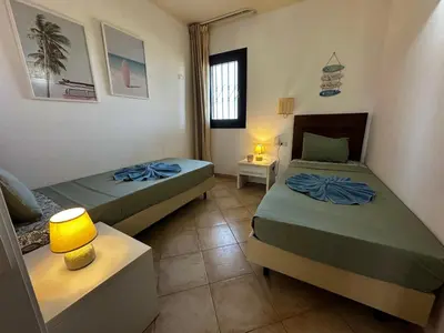a room with two beds and a lamp in it at Tropical Pool View - By Bobbywashere in Santa Maria