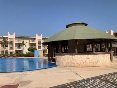 a building with a gazebo next to a swimming pool at Tropical Pool View - By Bobbywashere in Santa Maria