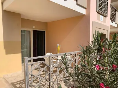 a balcony of a house with pink and yellow walls at Tropical Pool View - By Bobbywashere in Santa Maria