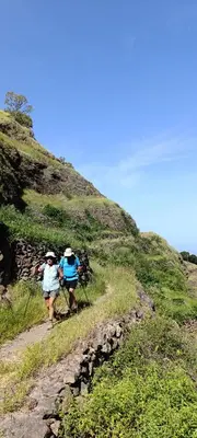 two people walking up a hill on a trail at Oiá Paúl in Paul