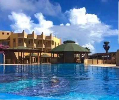 a large swimming pool in front of a building at Tropical African Vibe in Santa Maria