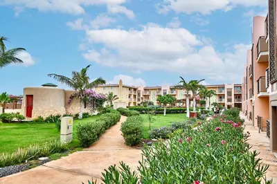 a courtyard at a resort with flowers and palm trees at Tropical African Vibe in Santa Maria