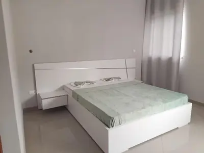 a white bedroom with a bed and a window at Assomada Comfort Ap in Assomada