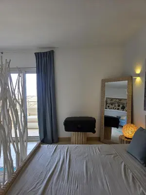 a bedroom with a bed and a mirror and a chair at Ricky's - minha kas, tju kaza in Santa Maria