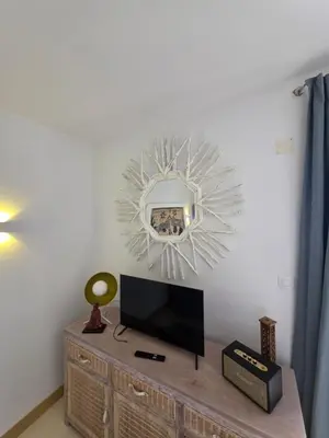 a living room with a tv and a mirror at Ricky's - minha kas, tju kaza in Santa Maria