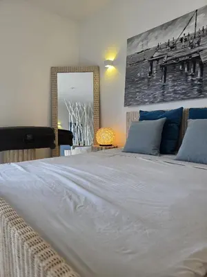 a bedroom with a large white bed with blue pillows at Ricky's - minha kas, tju kaza in Santa Maria