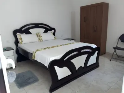 a bedroom with a black and white bed and a chair at Cafofo in Tarrafal