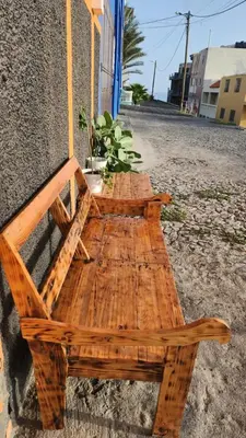 a wooden bench sitting on the side of a building at Please Read Email-Free EARLY Check In & Out-No Walk-Ins or Cash Accepted-Meeting Point Hostels in São Filipe