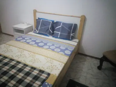 a small bed with blue and white pillows on it at Bar Residencial Frontera in Mindelo
