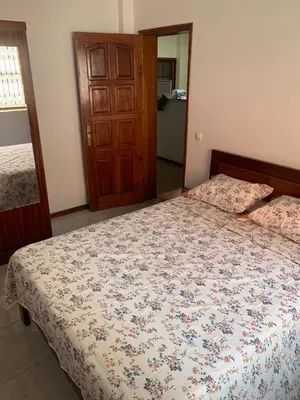 a bedroom with a bed with a floral comforter at Two Bedroom Condo, Mindelo in Mindelo